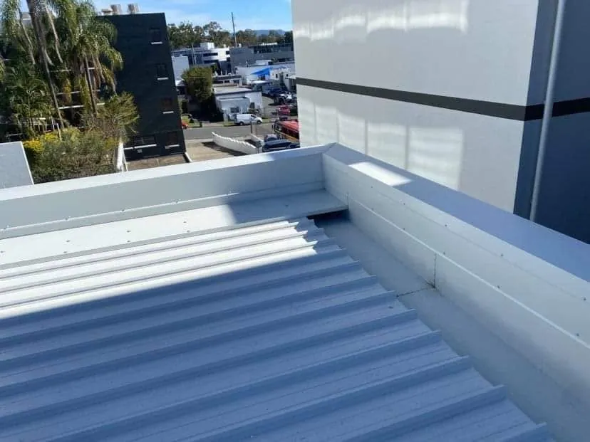 Corrugated roof with box gutter and parapet flashings