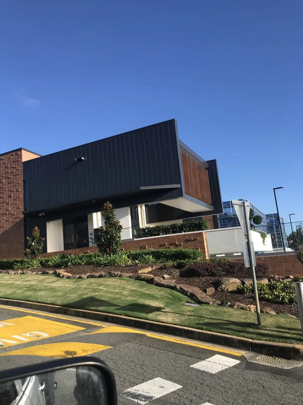 Dark standing seam façade with timber feature fins on a commercial building