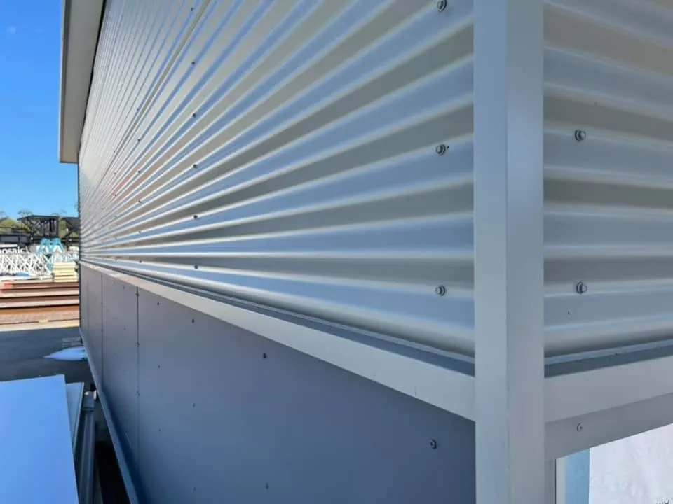Close-up of white corrugated cladding over flat panels