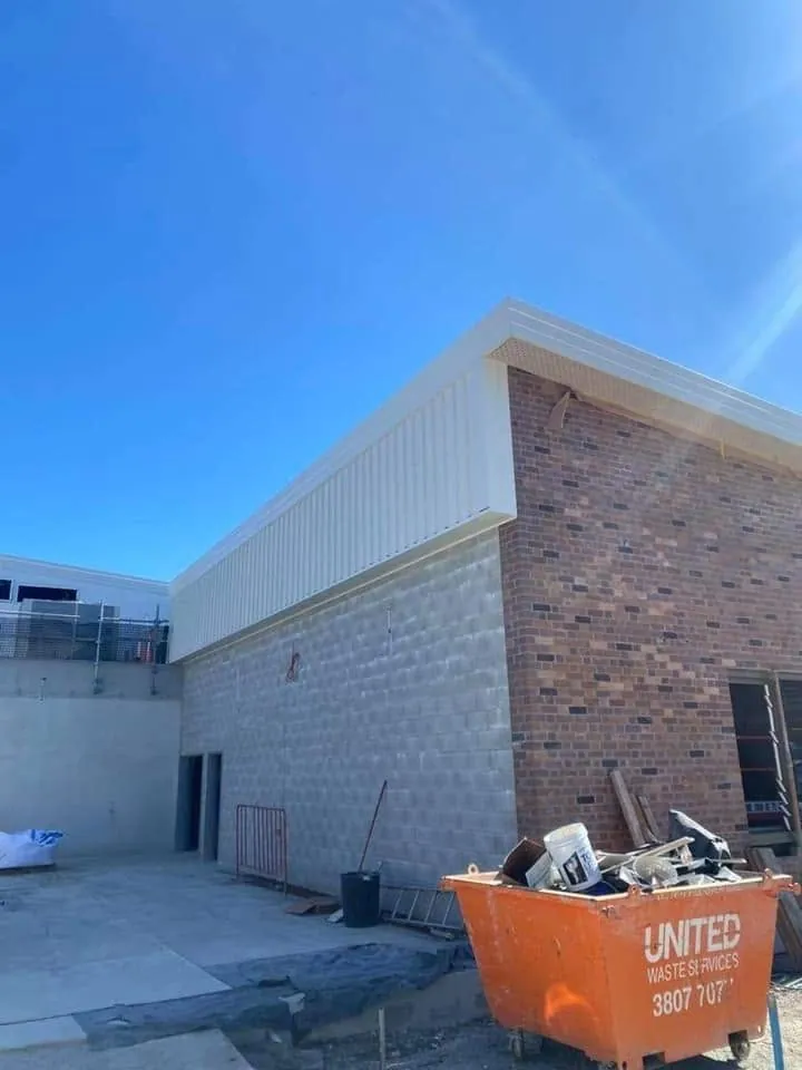 White fascia and wall cladding on a brick building
